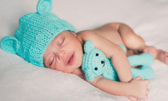 Baby laying with teddy bear